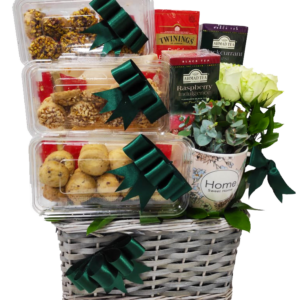 A gift basket containing Eid cookies and Tea and with roses and ribbons