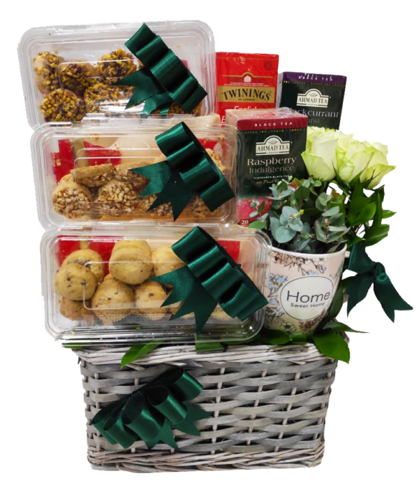 A gift basket containing Eid cookies and Tea and with roses and ribbons