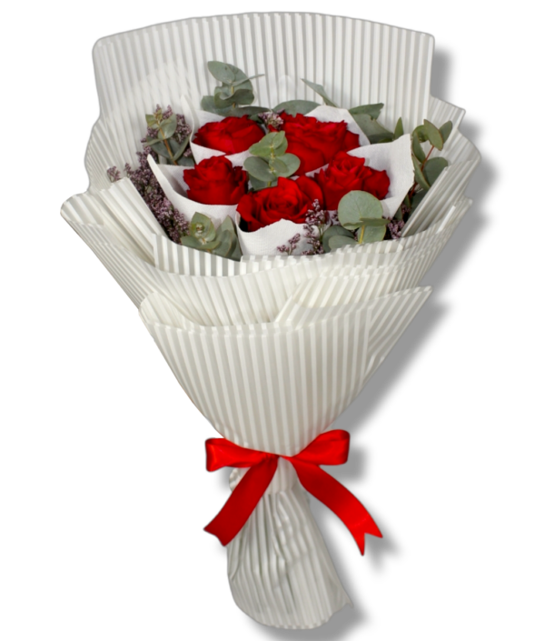 A flower bouquet of 5 red roses with green leaves and white wrapping paper