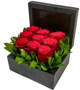 A black flower box of red roses with green leaves