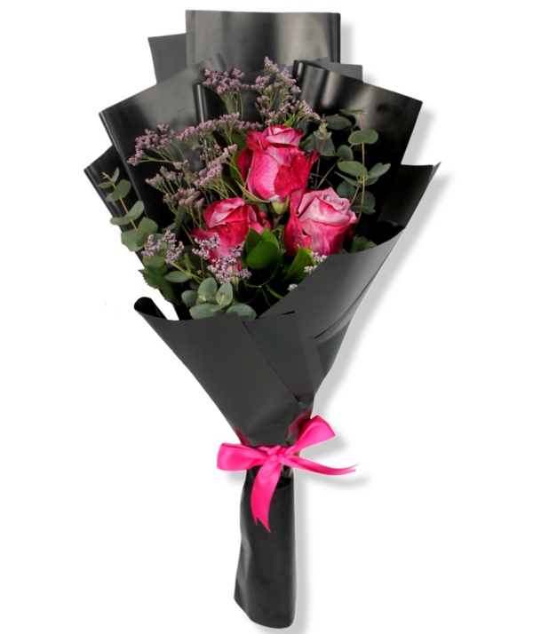 A small flower bouquet of 3 purple roses with green leaves and black wrapping paper