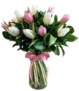 A flower vase of white and pink tulips with green leaves