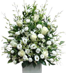 A large flower arrangement of white roses, lisianthus and orchids with green leaves