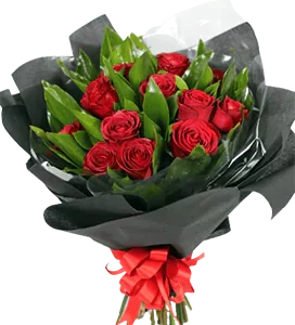 A flower bouquet with red roses and ruscus greenery, wrapped in black and tied with a big ribbon